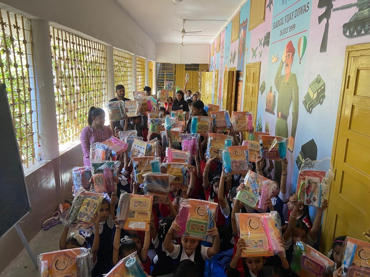 Volunteers and children at a school kit distribution