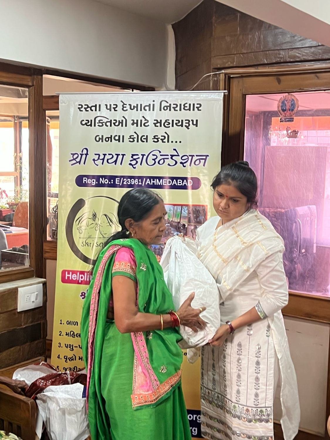 An elderly woman receiving a monthly ration kit