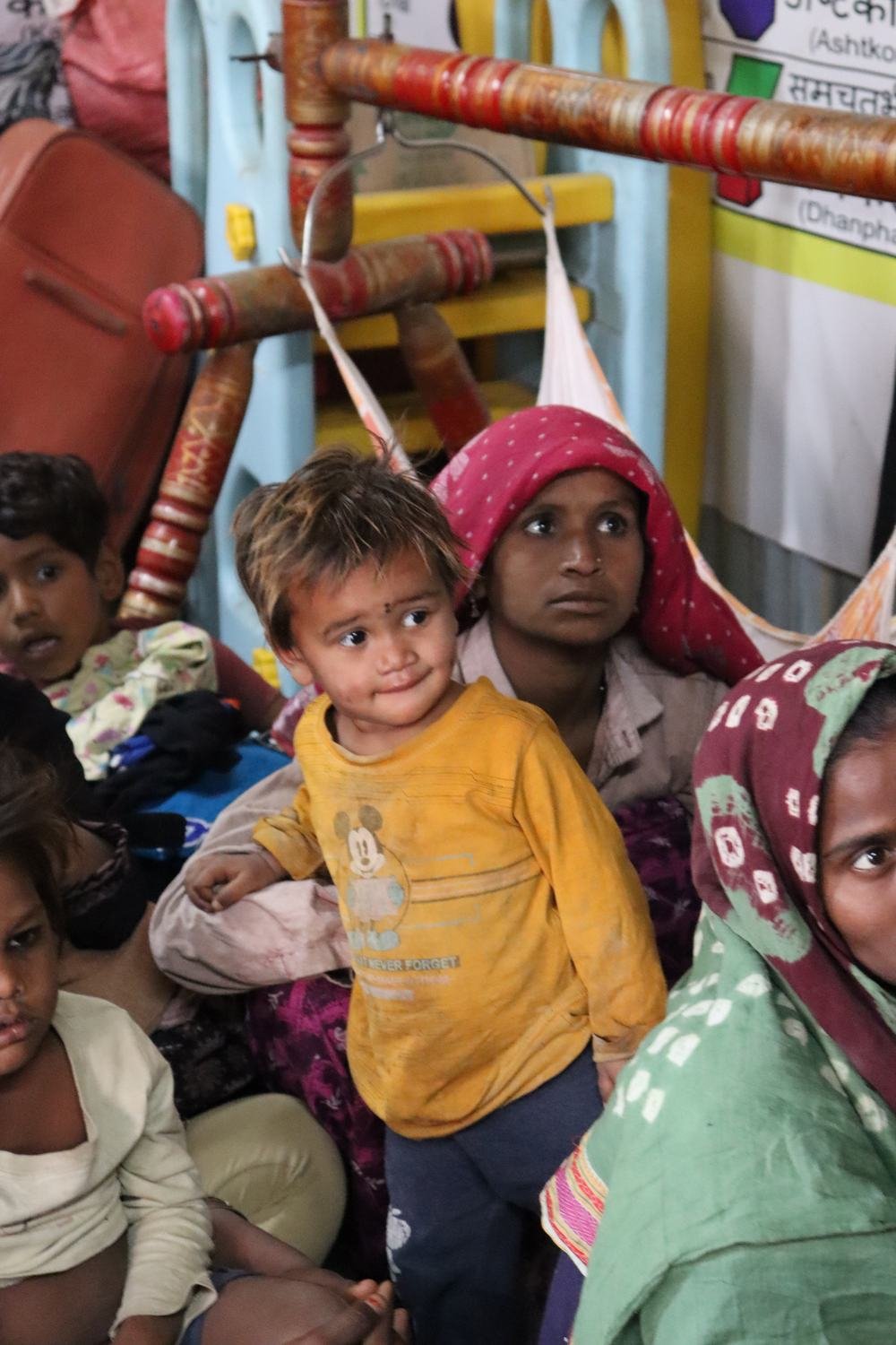 A child holding a new blanket at a shelter